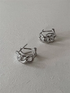 Détail de boucles d'oreilles anneaux argentées avec une finition polie miroir brillante
