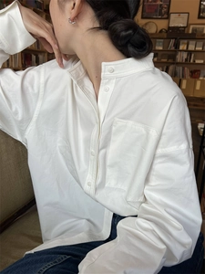 Détail d'une chemise blanche à manches longues avec col montant et poche de poitrine carrée