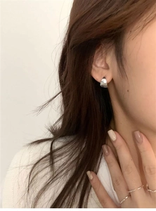 Close-up of minimalist geometric silver earrings worn by model for a refined look