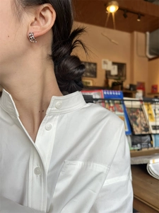 Boucles d'oreilles créoles chaîne argentée portées par un mannequin en décor chic