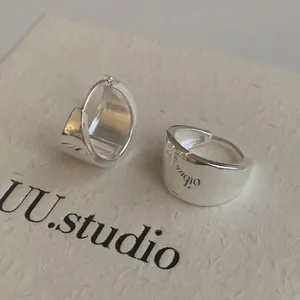 Minimalist silver triangle huggie earrings with polished finish and engraved letters