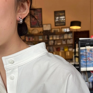 Boucles d'oreilles minimalistes en chaîne argentée avec finition polie sur un modèle