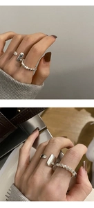 Detalle de anillos apilados de plata de ley con diseños geométricos e irregulares