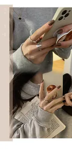Detalle de anillo de plata con cuentas y corazón con collar dorado en modelo