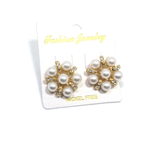 Boucles d'oreilles fleuries avec perles blanches et strass sur une base dorée
