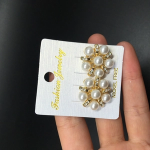 Détail de boucles d'oreilles élégantes en forme de fleur de perle avec strass scintillants