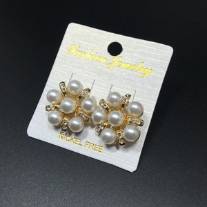 Détail de boucles d'oreilles fleurs élégantes avec perles et cristaux sur support