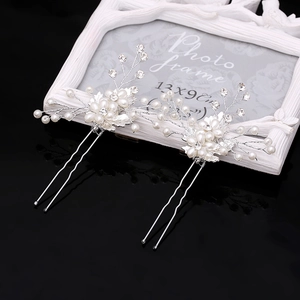 Elegant bridal hair pins set with white pearls and rhinestones on a black background