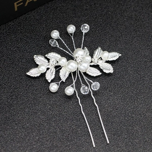 Détail d'une épingle à cheveux de mariée avec perles blanches et feuilles d'argent
