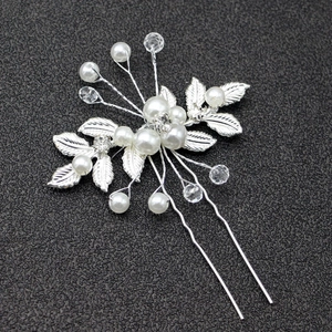 Détail de l'épingle à cheveux mariée avec perles blanches, cristaux et feuilles argentées