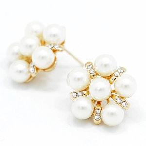 Gros plan détaillé de boucles d'oreilles fleurs dorées avec perles blanches et cristaux
