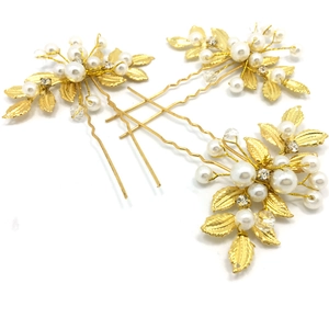 Détail de trois épingles à cheveux dorées avec feuilles, perles et strass pour mariée