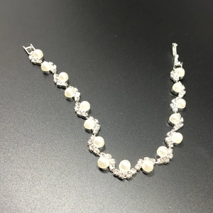 Dettaglio del bracciale da sposa con perle bianche e strass pavé scintillanti