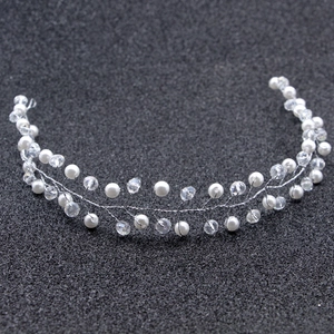 Macro shot of handmade bridal headband with white pearls and sparkling crystal beads
