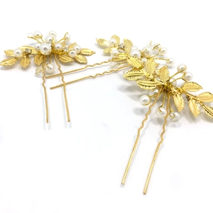 Détail de pinces à cheveux de mariée dorées avec perles blanches et feuilles d'olivier