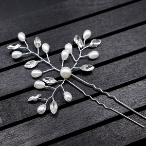 Silver bridal hair pin with handmade pearls and sparkling rhinestones on dark wood
