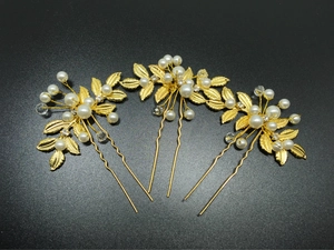 Détail de 3 épingles à cheveux dorées avec feuilles d'olivier, perles et cristaux