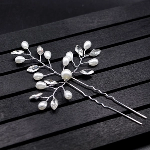 Detail of bridal hair pin with pearls and crystals on a professional black display