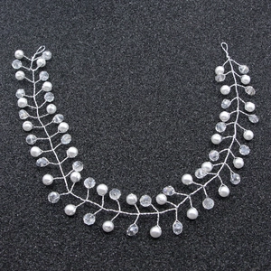 Close-up of handmade bridal hair vine with white pearls and sparkling crystal beads