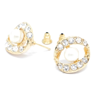 Vue macro de boucles d'oreilles fleur dorées avec pavé de zircons et perles blanches