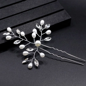 Detail of silver bridal hair pin with pearls and marquise rhinestones on black background