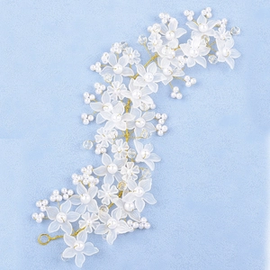 Vue détaillée de la coiffe de mariée artisanale avec fleurs en résine mate et perles