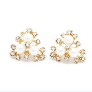 Détails macro des perles artificielles et strass brillants sur des clous d'oreilles dorés
