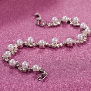 Vista macro del bracciale da sposa con perle bianche e accenti di strass scintillanti