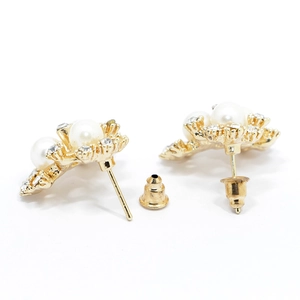 Vue détaillée de l'arrière des boucles d'oreilles dorées avec perles et fermoirs papillon