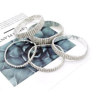 Detailansicht von fünf versilberten elastischen Strass-Armbändern mit funkelnden Kristallen