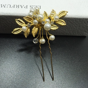 Détail de l'épingle à cheveux dorée avec perles blanches et strass étincelants