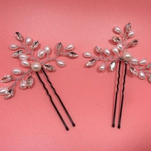 Detail of two handmade bridal hair pins with white pearls and crystals on silver wire