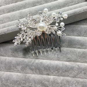 Détail du peigne à cheveux de mariée avec fleurs argentées, perles et strass cristal