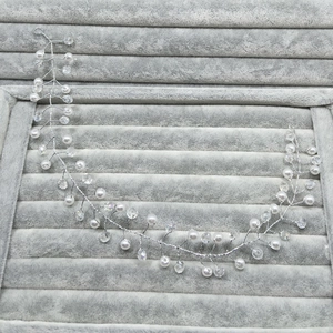 Detailed macro view of handmade bridal hair vine with silver wire, pearls and crystals