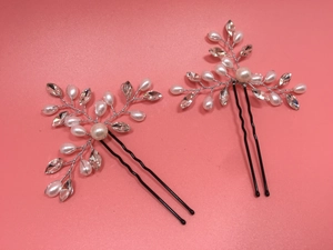 Detail of silver bridal hair pins with white pearls and marquise rhinestones on pink background
