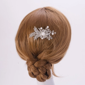 Détail du peigne à cheveux argenté avec strass brillants et perles porté par un modèle