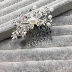 Vue détaillée d'un peigne à cheveux argenté avec perles et strass brillants pour mariée