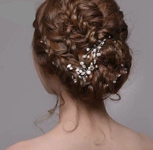 Détail d'une vigne de cheveux de mariée avec perles blanches et cristaux sur une tresse