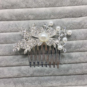 Détails d'un peigne à cheveux argenté avec strass scintillants et perles élégantes