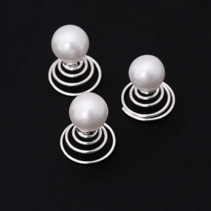 Three bridal hair pins with white pearls and silver spiral bases on black background