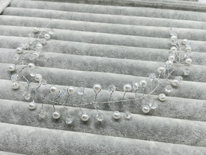 Detailed macro view of handmade bridal hairband with silver wires, pearls, and crystals
