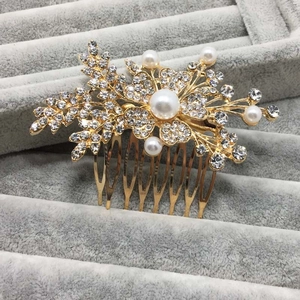 Détail d'un peigne à cheveux floral doré avec perles blanches et strass en cristal étincelants
