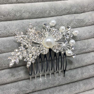 Détail d'un peigne de mariée avec fleurs en cristal et perles sur velours gris chic