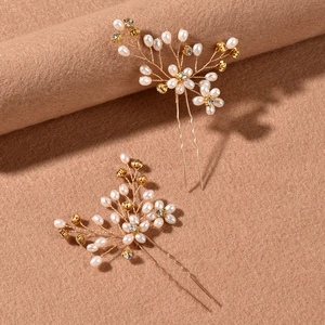 Detailed close-up of handmade bridal hair pins with white pearls and gold wire floral design