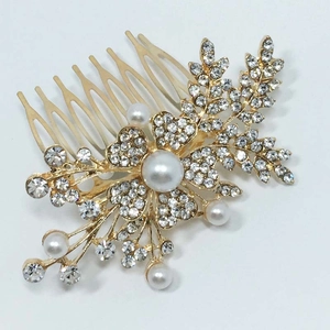 Détail du peigne de mariage doré avec cristaux, motifs floraux et perles blanches