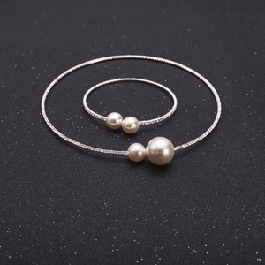 Detailed view of silver bridal jewelry set with sparkling rhinestones and white pearls