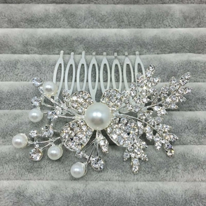 Détail du peigne de mariée avec perles blanches et cristaux sur base florale argentée