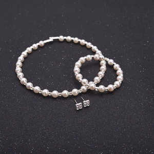 Detail shot of bridal jewelry set with 8mm pearls and sparkling rhinestones on black
