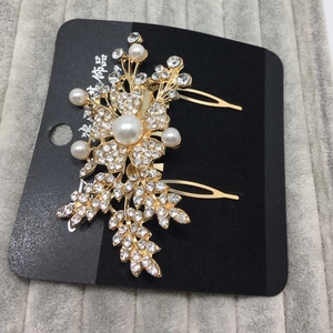 Détail du peigne doré à fleurs orné de perles blanches et cristaux brillants