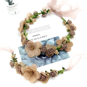 Detail of bohemian floral crown with beige silk flowers and organza ribbon ties